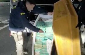 Policial faz o sinal da cruz após encontrar 50 quilos de crack dentro de um caixão funerário